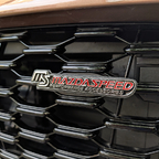 Emblem "Mazdaspeed" für den Kühlergrill; gibt es in der Bucht. Zusätzlich selbstgebauter Lückenfüller aus einer Siebdruckplatte passgenau für "in die Raute" (schwarz), ein Alublech mit etwas größer als die Raute, Befestigungsplatte, Schrauben.